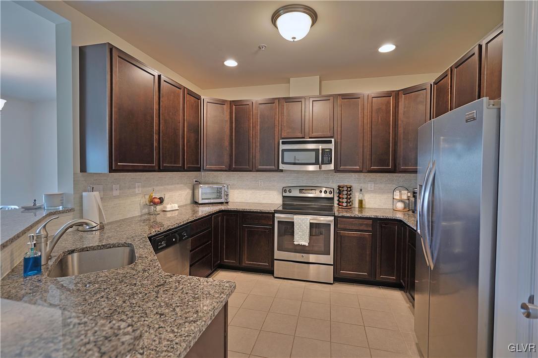 229 Snapdragon Way Allentown, PA 18104 - Photo 5 of 27 a kitchen with kitchen island granite countertop a sink stainless steel appliances and cabinets