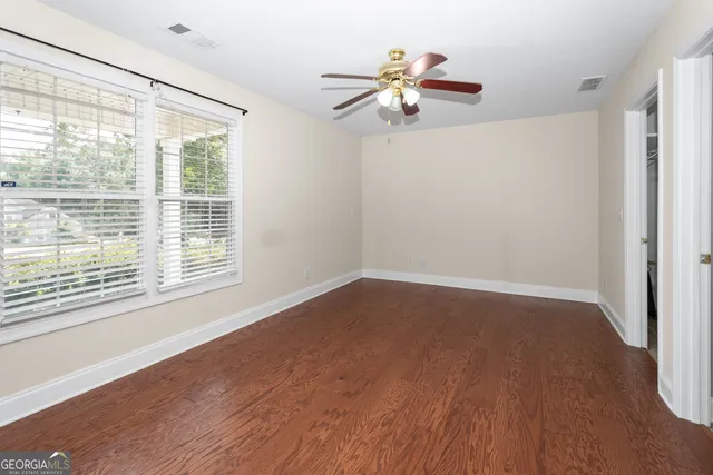 a view of an empty room and chandelier fan
