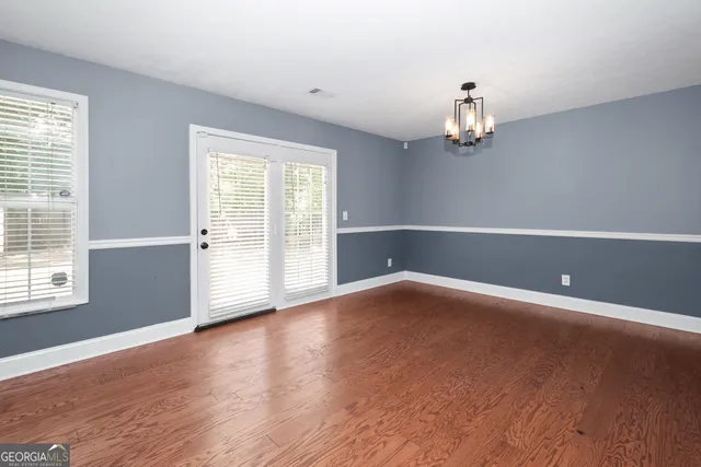 a view of a livingroom with wooden floor and chandelier