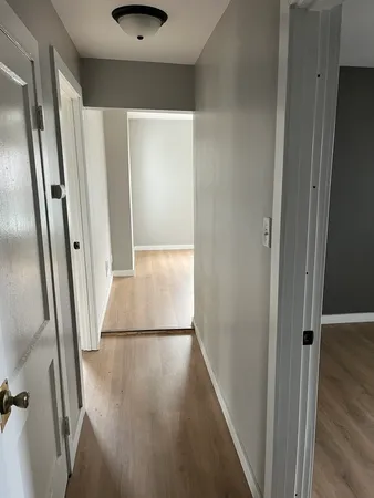 a view of a hallway with wooden floor and staircase