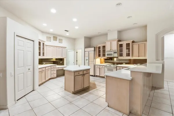 a kitchen with white cabinets and appliances