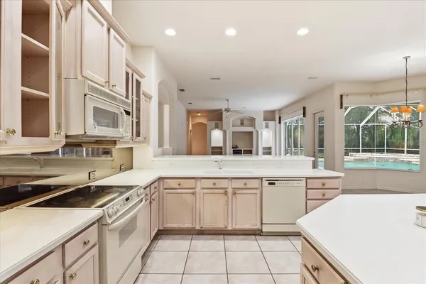 a large white kitchen with a sink and cabinets