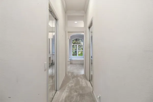 a view of a hallway with white walls and a window