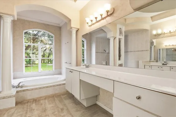 a bathroom with a tub a sink and a window