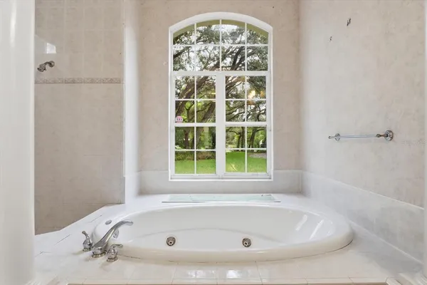 a white bath tub sitting in a bathroom next to a window