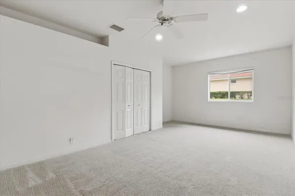 an empty room with a ceiling fan and a window