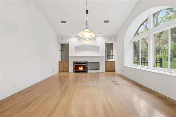 a view of an empty room with a fireplace and a window