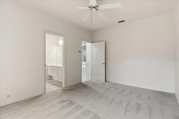 an empty room with a chandelier fan and closet