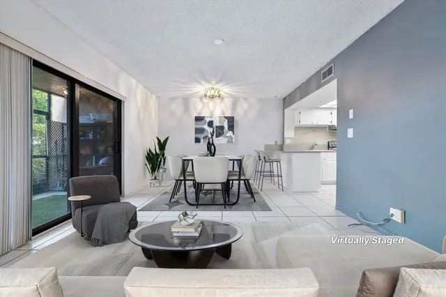a living room with furniture and a dining table with kitchen view