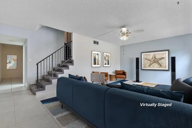 a living room with furniture flowerpot and a chandelier