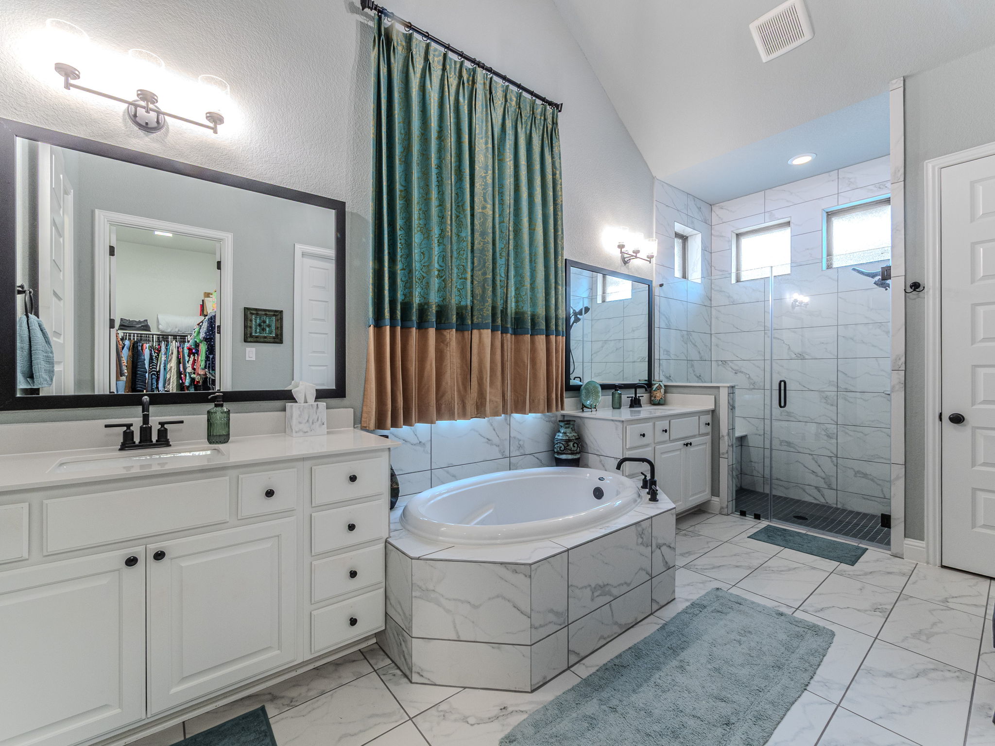 112 Hollytree Court Georgetown, TX 78628 - Photo 16 of 40 Full bathroom featuring a shower stall, light marble finish floors, vaulted ceiling, two vanities, and a garden tub