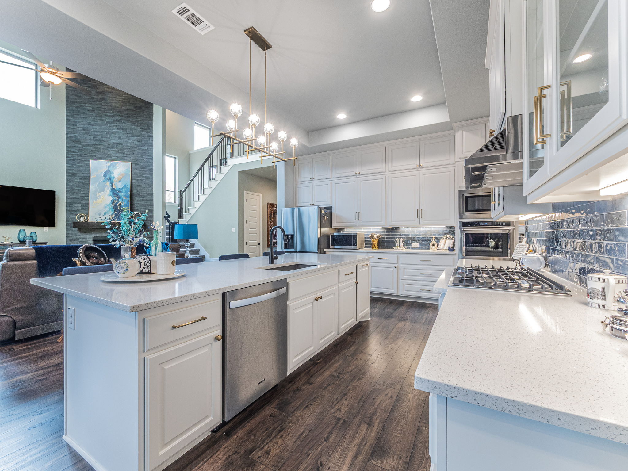 112 Hollytree Court Georgetown, TX 78628 - Photo 39 of 40 a kitchen with stainless steel appliances kitchen island granite countertop a sink dishwasher a stove and a dining table with wooden floor