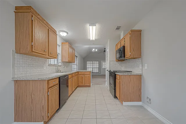 a kitchen with stainless steel appliances granite countertop a sink and dishwasher a stove top oven with wooden floor