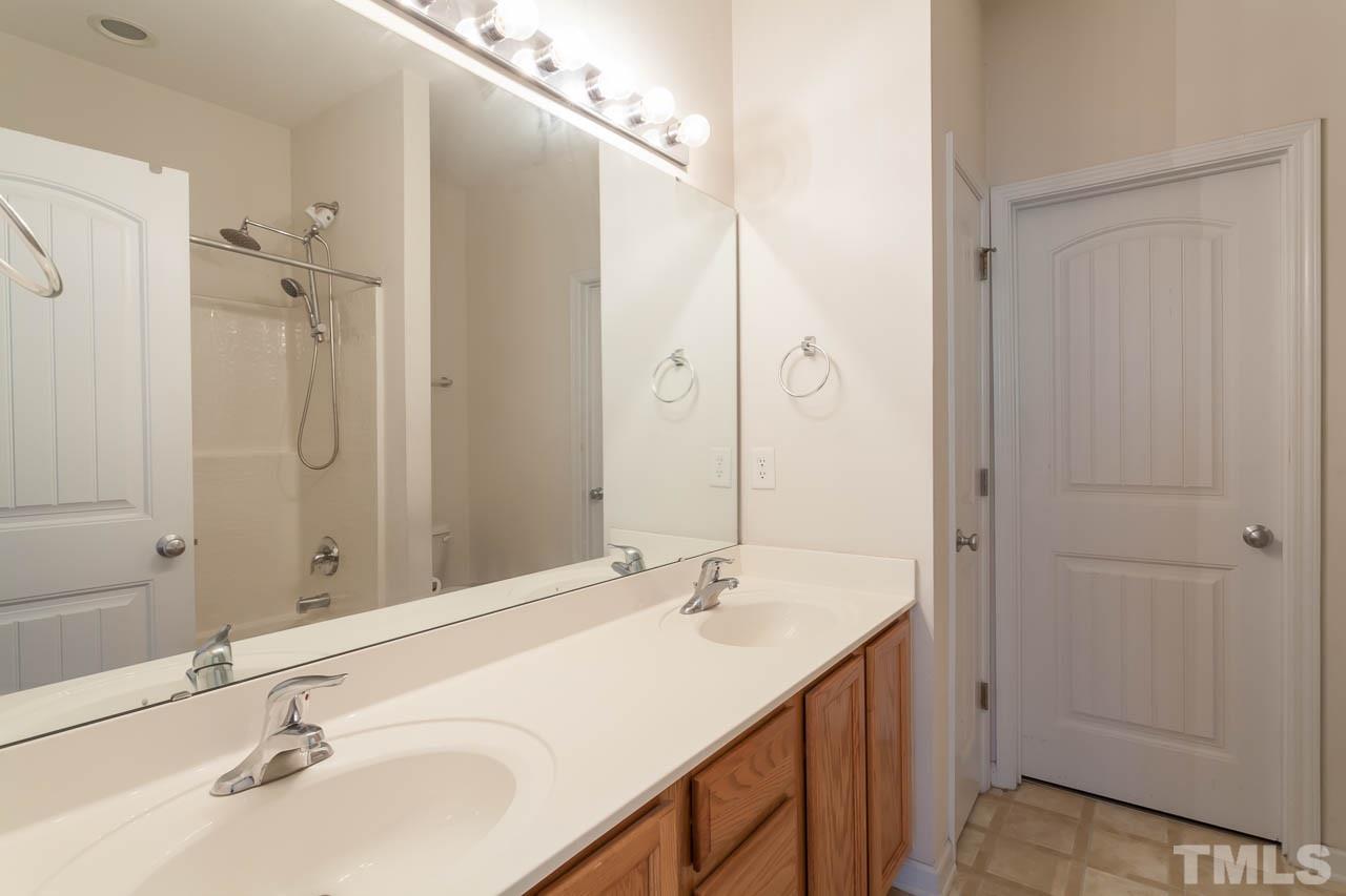 4708 Altha Street Raleigh, NC 27606 - Photo 15 of 25 a bathroom with a sink and a mirror