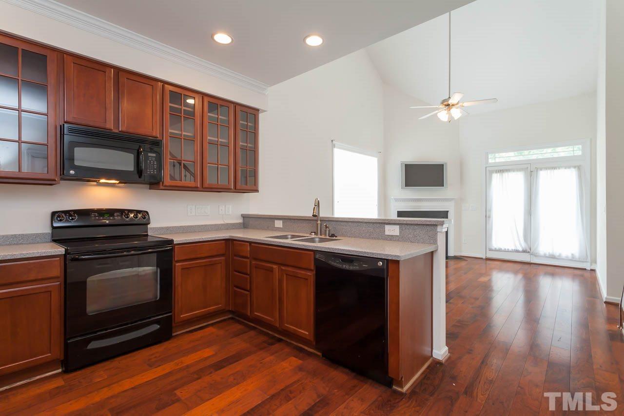 4708 Altha Street Raleigh, NC 27606 - Photo 8 of 25 a kitchen with stainless steel appliances granite countertop a stove a sink and a microwave