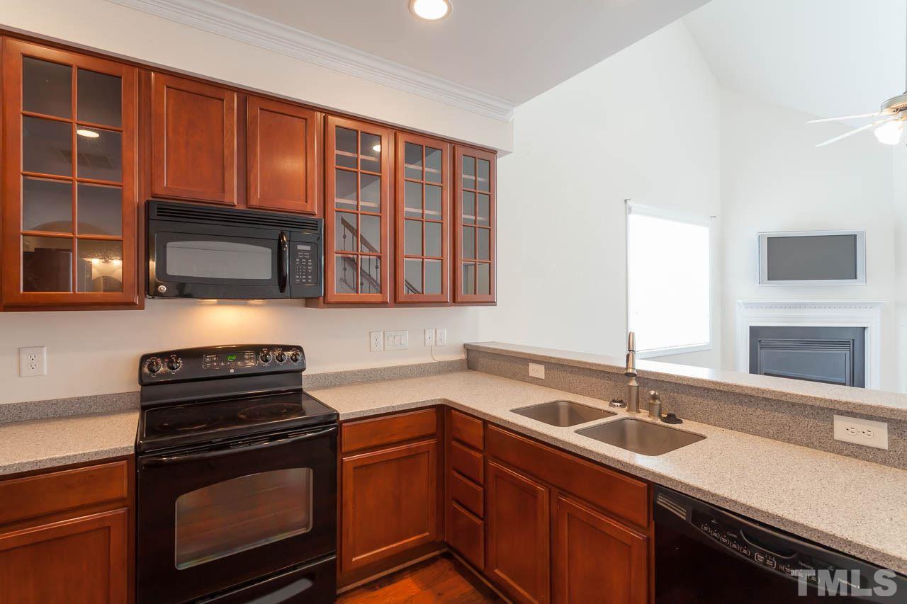 4708 Altha Street Raleigh, NC 27606 - Photo 10 of 25 a kitchen with a sink stove and microwave