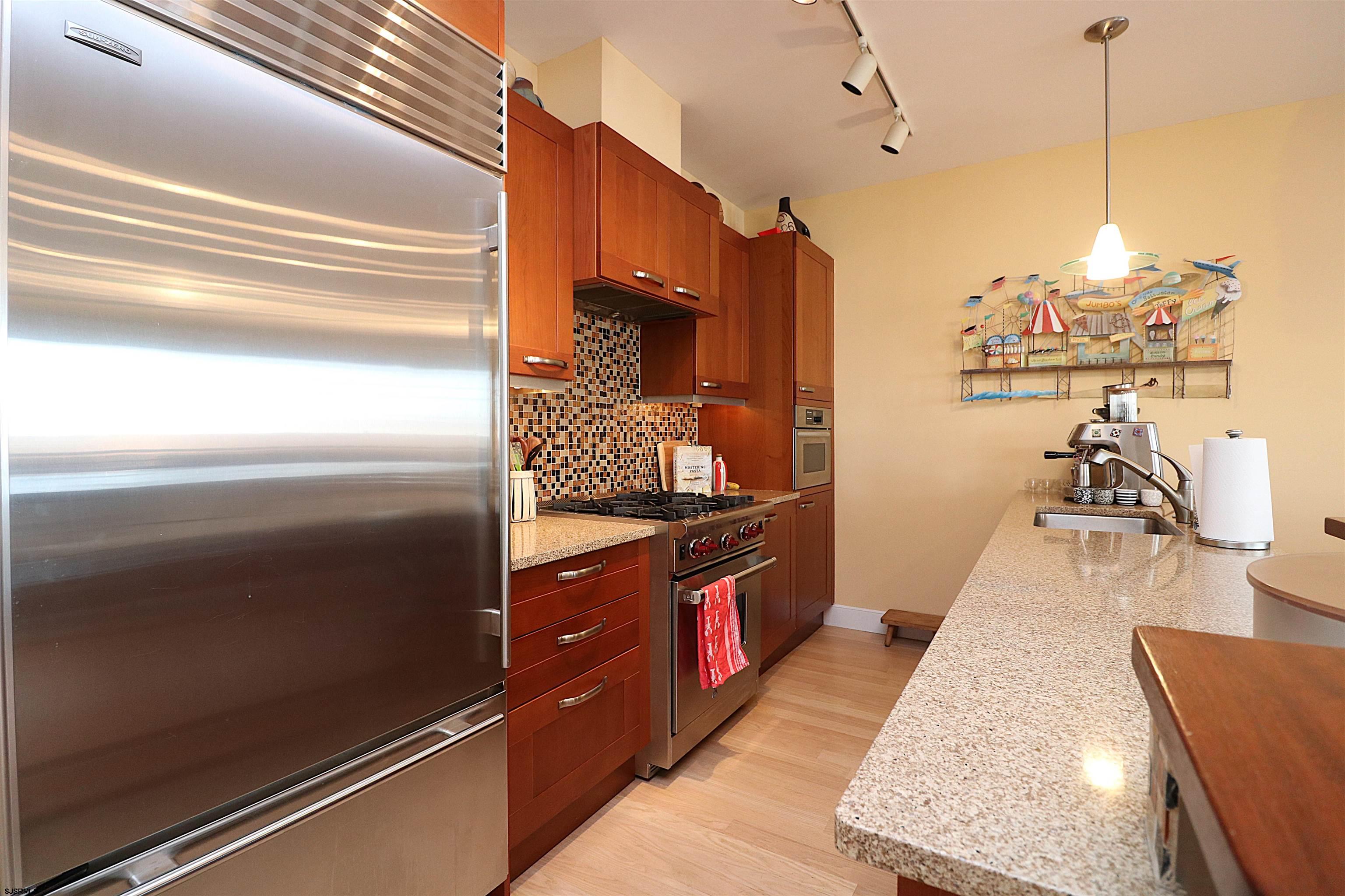 214 North Decatur Avenue, Unit B Margate City, NJ 08402 - Photo 16 of 23 a kitchen with stainless steel appliances granite countertop a refrigerator and a wooden floor