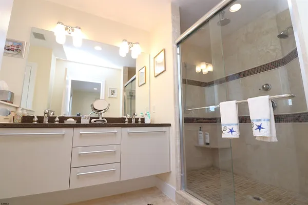 a bathroom with a sink a mirror and shower