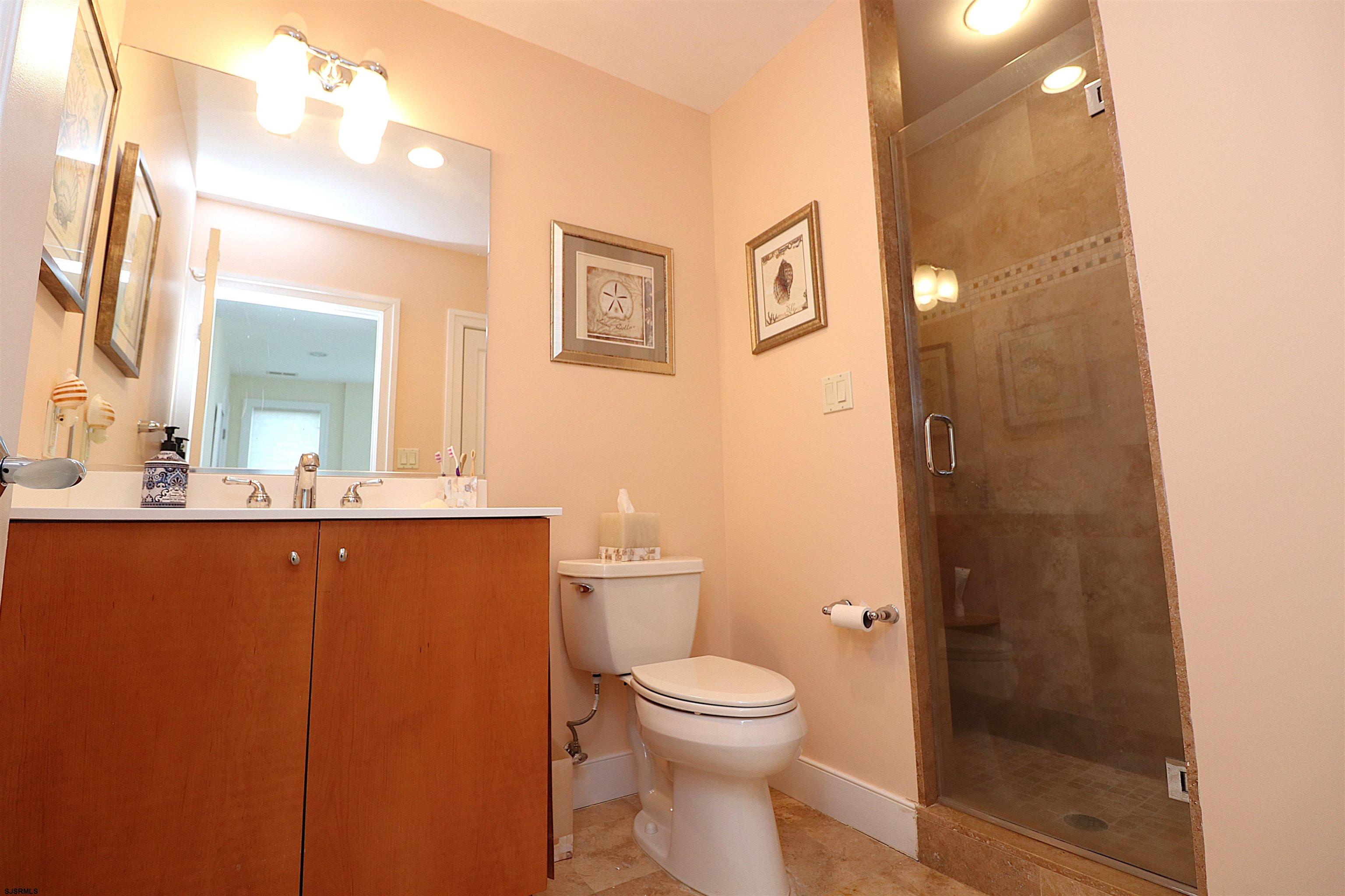 214 North Decatur Avenue, Unit B Margate City, NJ 08402 - Photo 7 of 23 a bathroom with a toilet a sink and mirror