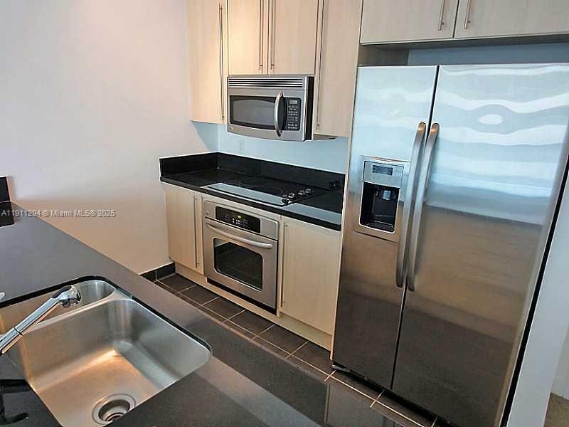 1111 Southwest 1st Avenue, Unit 1123N Miami, FL 33130 - Photo 6 of 16 a kitchen with a sink and stainless steel appliances