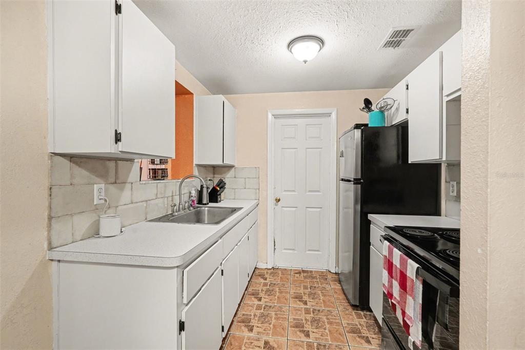 9528 River Road Spring Hill, FL 34608 - Photo 12 of 30 a kitchen with a sink a stove and a refrigerator