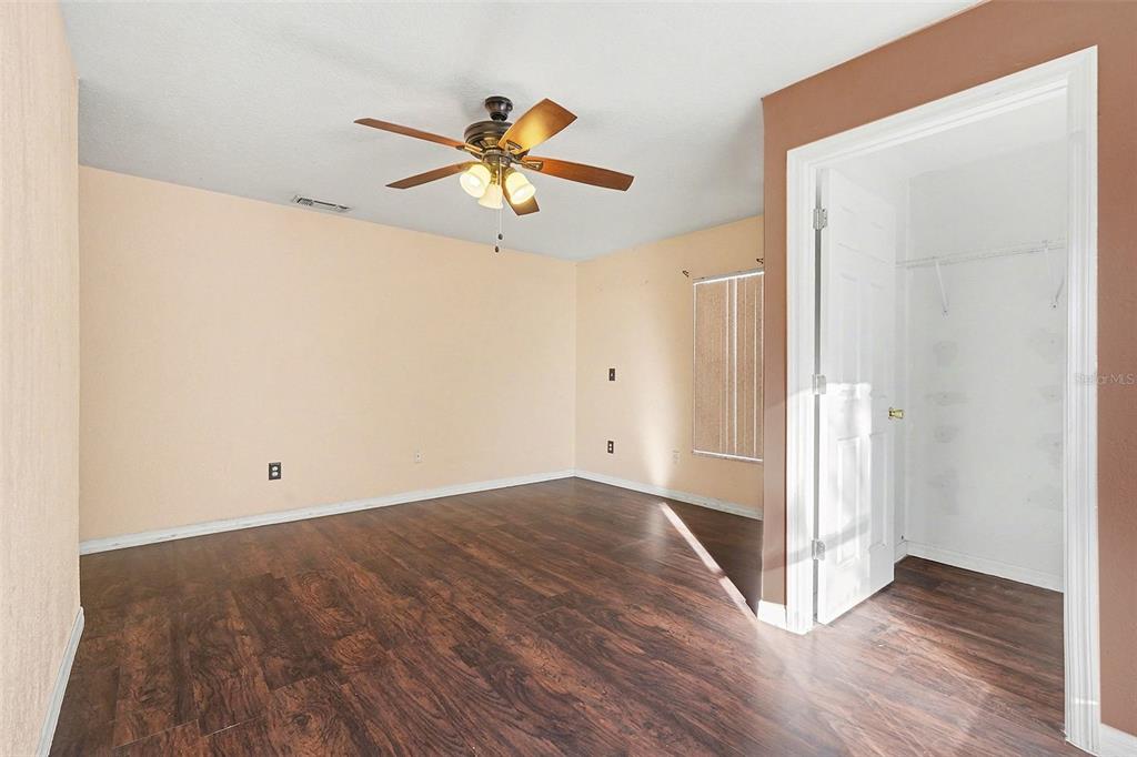 9528 River Road Spring Hill, FL 34608 - Photo 19 of 30 an empty room with wooden floor fan and windows