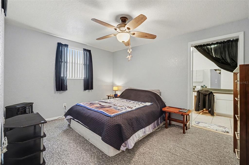 9528 River Road Spring Hill, FL 34608 - Photo 24 of 30 a bedroom with a bed and a chandelier