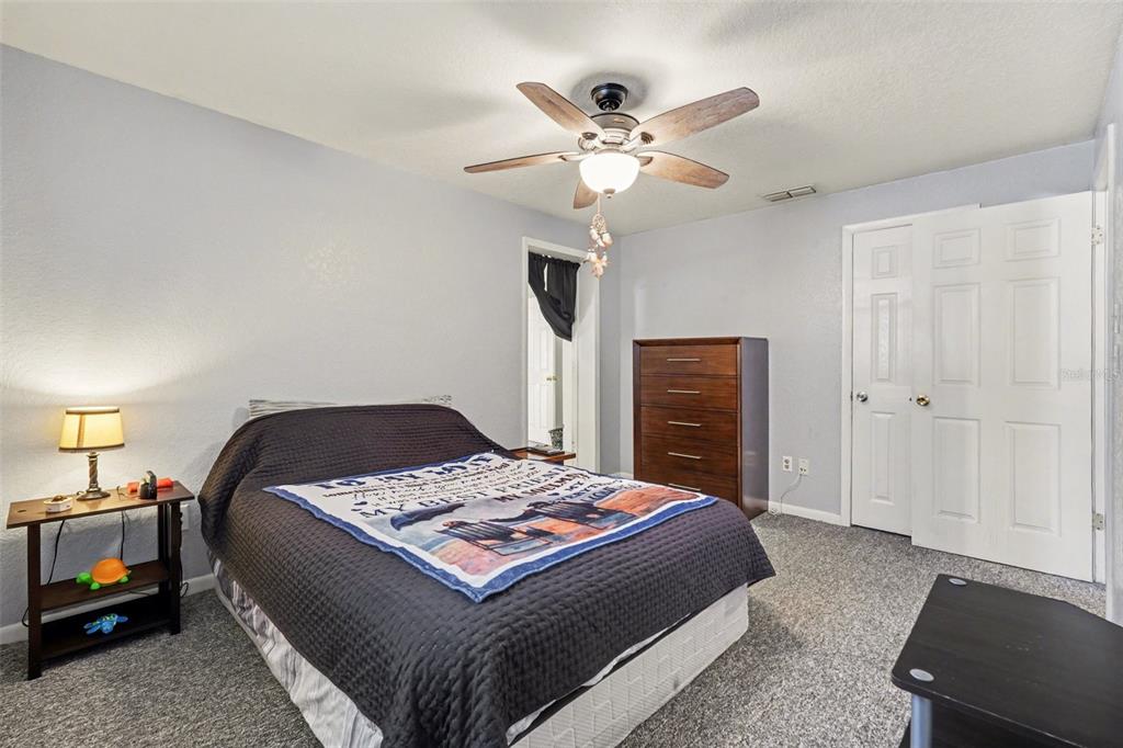 9528 River Road Spring Hill, FL 34608 - Photo 25 of 30 a bedroom with a bed and a chandelier