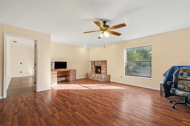 a view of a workspace with furniture and a window
