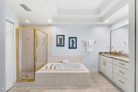 a spacious bathroom with a tub a double vanity sink and a mirror