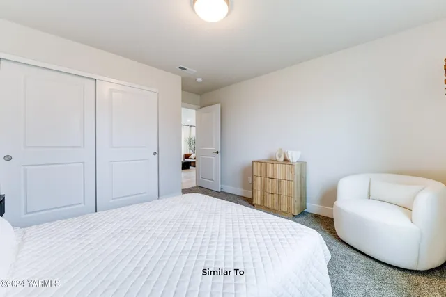 a bedroom with a bed and a chair