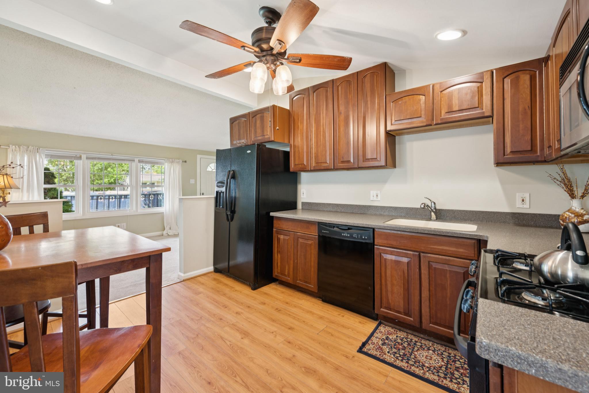 641 North Coles Avenue Maple Shade, NJ 08052 - Photo 4 of 23 a kitchen with stainless steel appliances granite countertop a refrigerator a sink dishwasher a stove a dining table and chairs with wooden floor