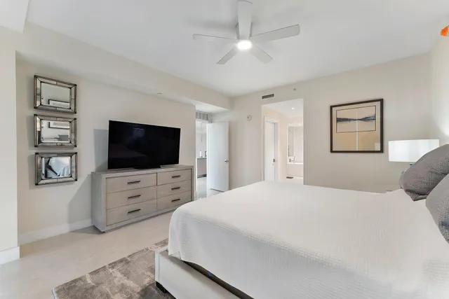 a bedroom with a bed a flat screen tv and dresser