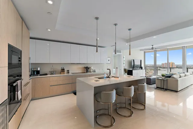 a kitchen that has a lot of cabinets in it with stainless steel appliances granite countertop a stove a sink dishwasher and white cabinets with wooden floor