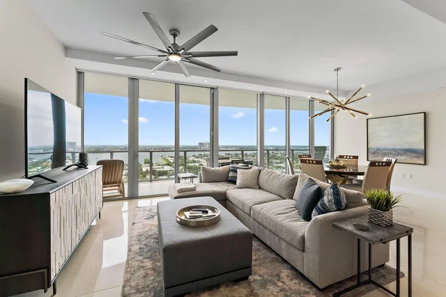 a living room with furniture a large window and a chandelier