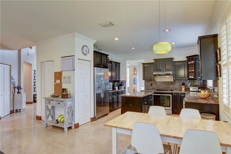 3863 Falcon Ridge Circle Weston, FL 33331 - Photo 14 of 52 a kitchen with stainless steel appliances kitchen island granite countertop a refrigerator stove microwave and sink