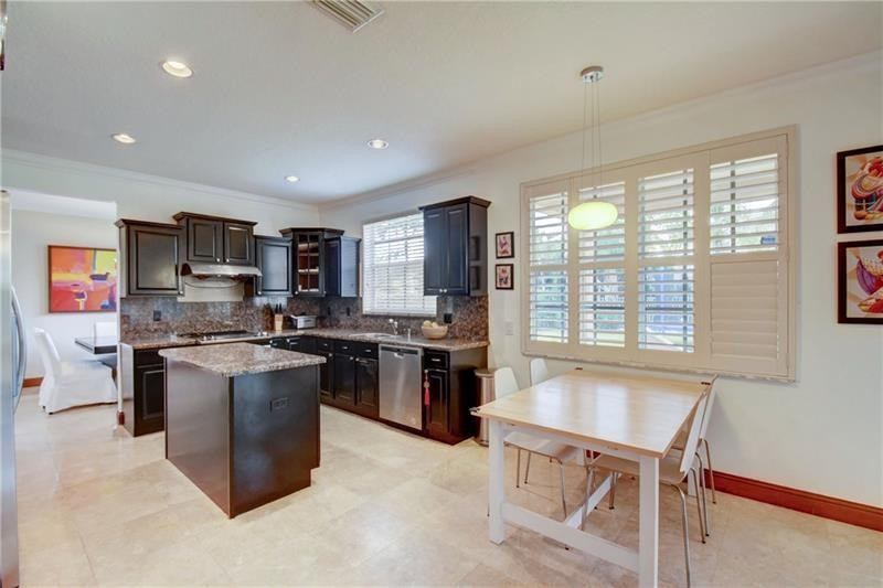 3863 Falcon Ridge Circle Weston, FL 33331 - Photo 15 of 52 a kitchen with kitchen island a sink stove and refrigerator