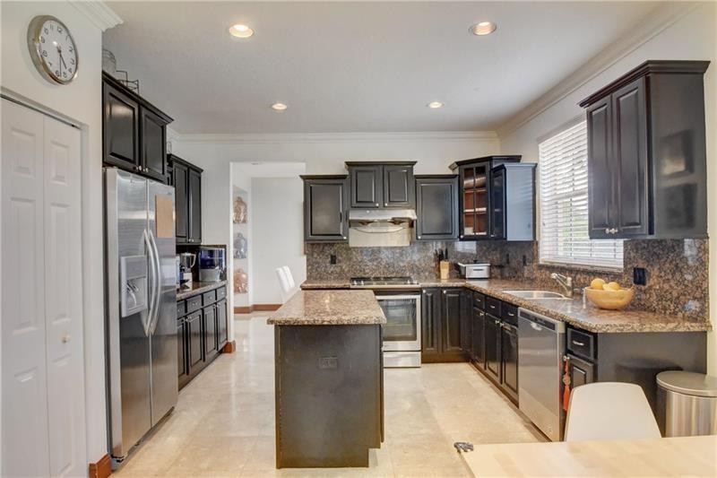 3863 Falcon Ridge Circle Weston, FL 33331 - Photo 4 of 52 a kitchen with stainless steel appliances granite countertop a refrigerator stove microwave and sink