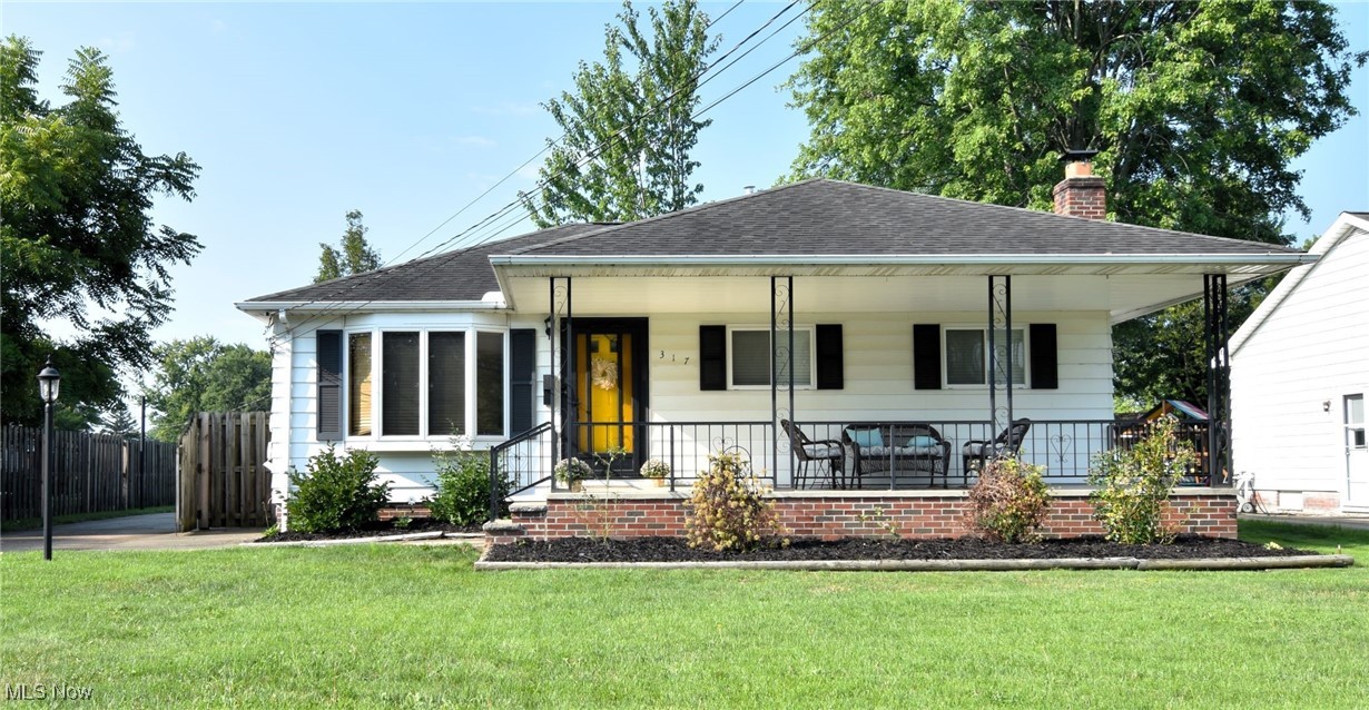 View of front of home featuring covered porch and a front yard