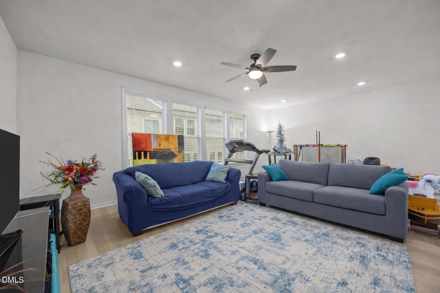 7015 Gentle Pine Place Raleigh, NC 27613 - Photo 16 of 41 a living room with furniture a ceiling fan and a rug