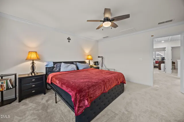 a bedroom with a bed and a lamp on dresser