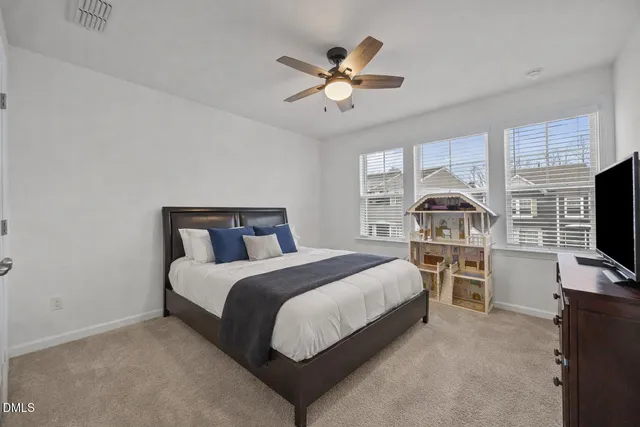 a spacious bedroom with a bed and a flat screen tv