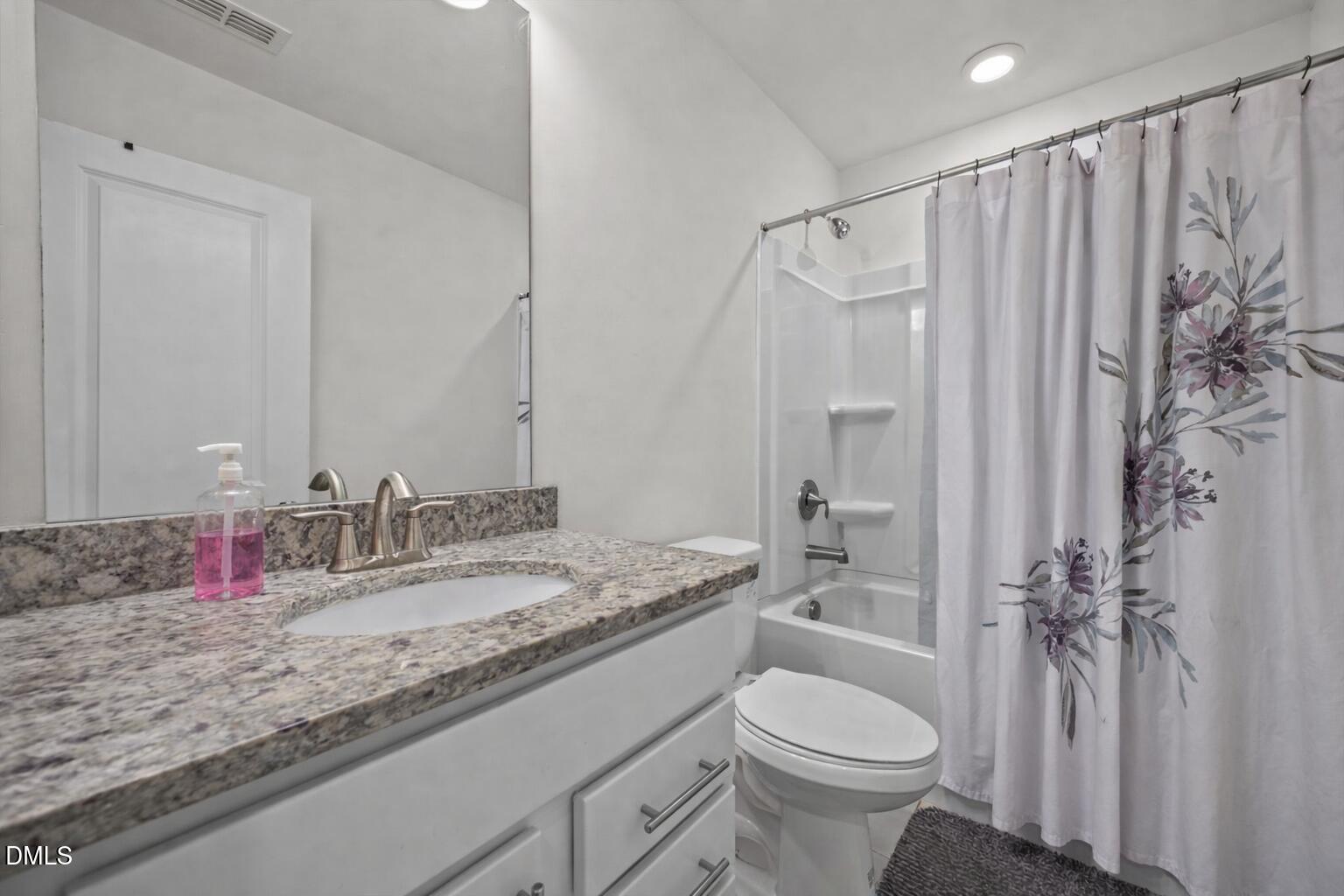 7015 Gentle Pine Place Raleigh, NC 27613 - Photo 30 of 41 a bathroom with a granite countertop sink toilet and shower