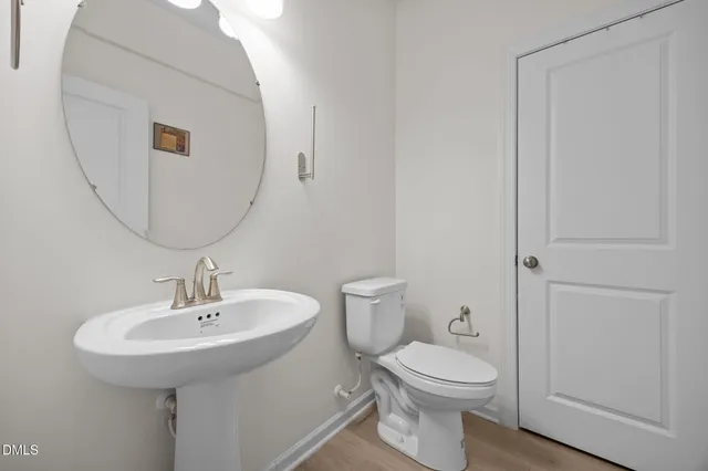 a bathroom with a toilet a sink and mirror