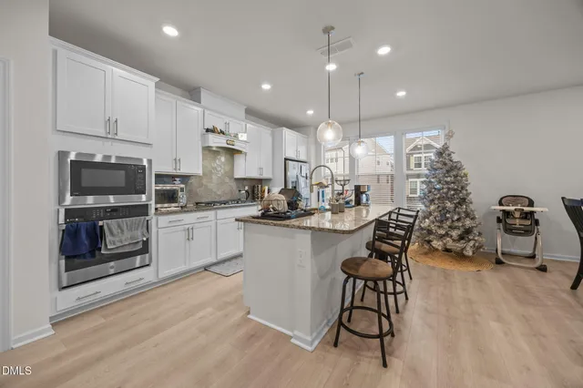a kitchen with kitchen island granite countertop a sink cabinets and stainless steel appliances
