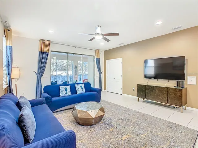 a large bed sitting in a bedroom next to a window and a chandelier