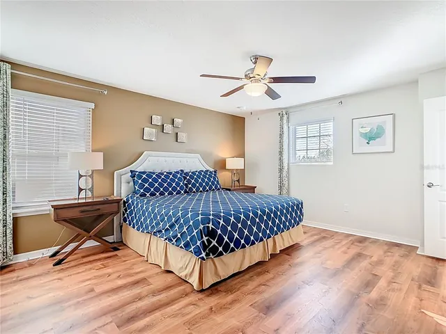 a room with furniture pool table wooden floor and windows