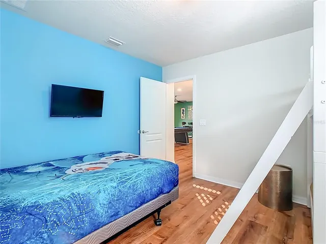 a bedroom with a bed and a lamp on the dresser