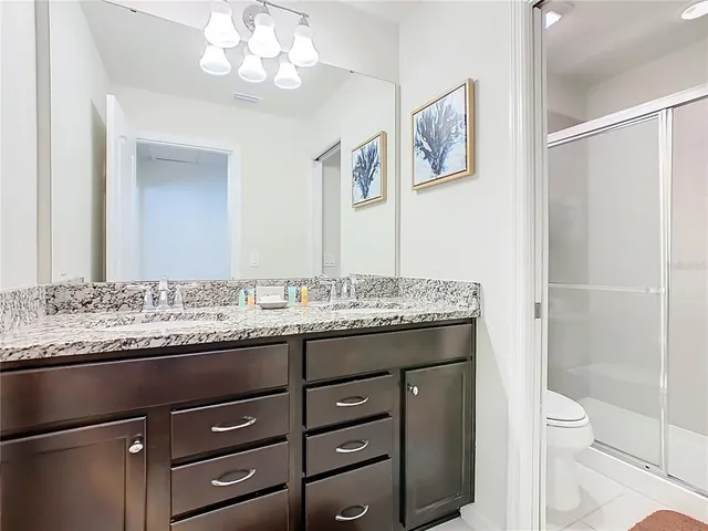 a bathroom with a granite countertop sink a mirror and a shower
