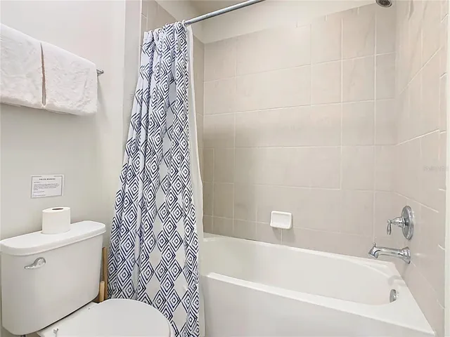 a bedroom with a bed and painting on the wall